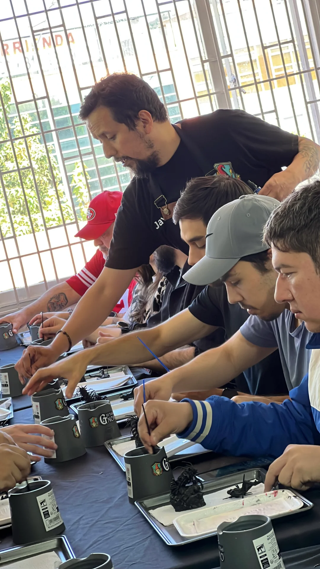 Aficionados compartiendo alrededor de una mesa de miniaturas